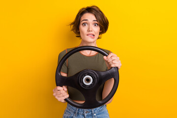 Poster - Photo of nervous woman wear trendy t-shirt hold steering wheel biting lips staring at accident isolated on yellow color background