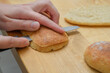 Chrupiąca świeża bułka pełnoziarnista krojona na pół nożem do pieczywa