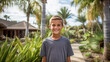 © OPPERMAN - Smiling 10 year old boy standing in a garden in a tropical climate.