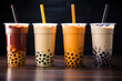 Variety of boba bubble tea with straws on a wooden table