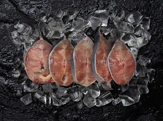 Wall Mural - Catfish slices on black stone background, top view