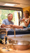 © Monkey Business - Senior Couple Camping In Countryside Relaxing Drinking Coffee Inside RV