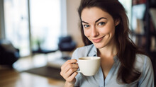 jeune femme brune cheveux long en train de boire un café dans son appartement