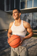 © Miljan Živković - Portrait of strong athlete man hold basketball ball wear white a-shirt