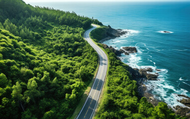 Poster - Aerial view of a road winding through green trees near the ocean. Generative AI