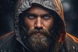 © Fotograf - A man with a beard wearing a rain jacket. This versatile image can be used to depict various outdoor activities, weather conditions, or fashion styles.