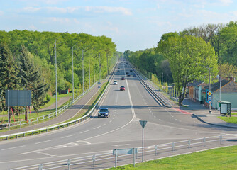 Asphalt road and green roadsides with bushes. Empty highway