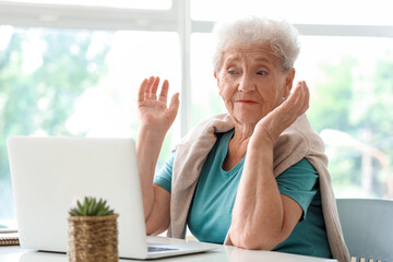 Sticker - Senior woman using laptop at home