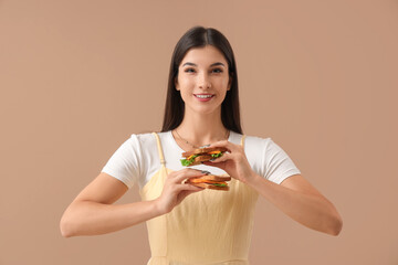 Wall Mural - Young woman with tasty sandwiches on color background