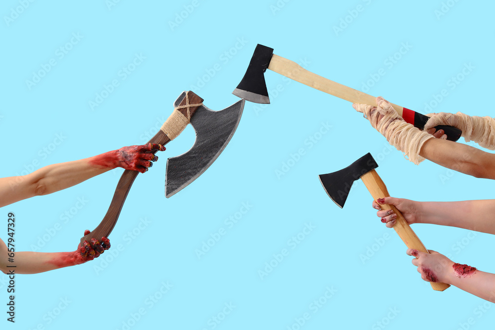 Zombie and mummy hands with axes on blue background. Halloween celebration