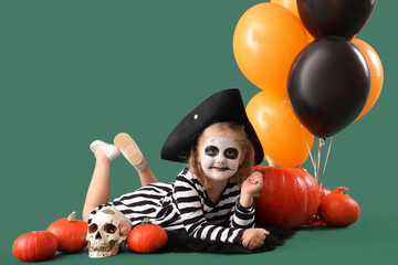 Poster - Little girl dressed for Halloween with pumpkins and balloons on green background