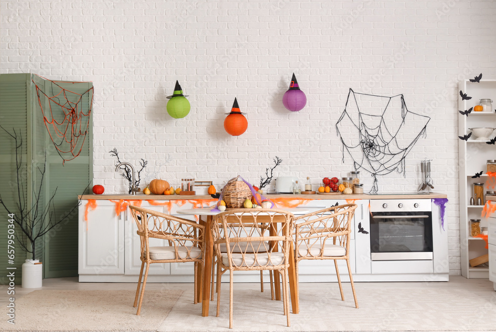Interior of light kitchen decorated for Halloween with counters and dining table