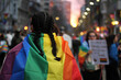 jovem leva a bandeira lgbt em marcha pela diversidade e o orgulho gay em meio aos manifestantes
