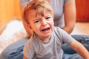 Wall Mural - A close up lifestyle portrait of a little toddler boy crying