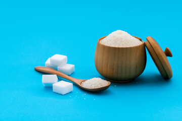 Wall Mural - Granulated sugar in a bowl on blue background