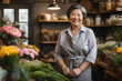 Portrait of a happy chinese mature woman standing in her flower shop. Standing at the entrance is a successful small business owner in an ordinary gray apron.