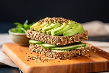 Whole Grain Bread Topped With Avocado Slices And Sesame Seeds