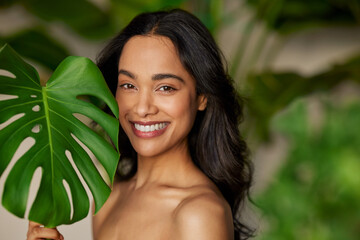 Wall Mural - beauty natural woman with monstera leaf looking at camera