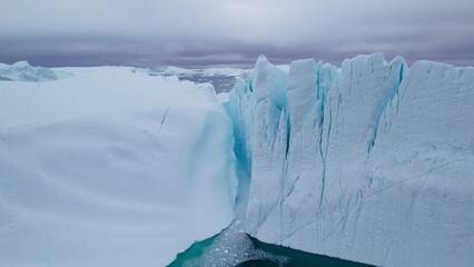 Poster - Aerial view flying between the iceberg peaks and large icebergs floating in Ilulissat Icefjord, Arctic Ocean, Greenland Ice Sheet, Icecap, Ilulissat, Climate Change
