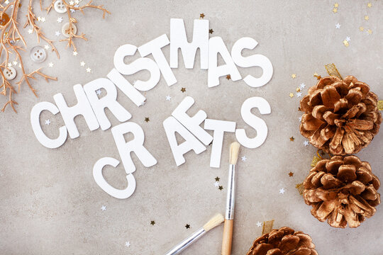 Christmas crafts in white lettering on mottled grey background with golden décor bits