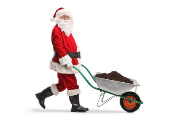 Poster - Full length profile shot of a santa claus pushing a wheelbarrow with soil