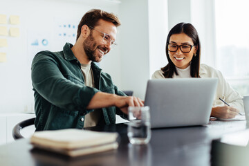 Poster - Two business people using a laptop together in an office