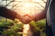 Hands shake in firm agreement beneath the softly diffused sunlight of translucent greenhouse panels, with a blurred backdrop of varied crops symbolizing a united venture in sustainable, controlled far