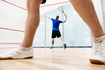 Wall Mural - Young sportive men, friends playing squash together on squash court. Heathy leisure time together. Concept of sport, hobby, healthy and active lifestyle, game, gym, ad