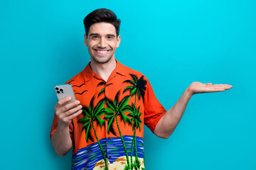 Sticker - Photo of funny young guy wear shirt hold arm product with iphone summer journey hotel mini bar discount isolated on blue color background