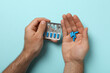 Blue viagra pills in a man's hand