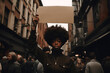 Black woman in the streets protesting, holding a sign
