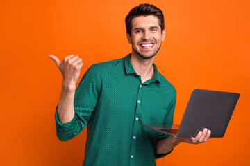 Aufkleber - Photo of candid young positive guy brunet hair directing finger mockup all options his service laptop isolated on orange color background
