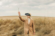 © Westend61 - Woman wearing virtual reality simulators gesturing in field