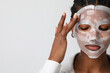 © face_reader_img - Portrait of young woman applies a hydro gel face mask. Skin care and beauty.
