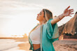 © Daniel - Portrait of one young woman at the beach with openened arms enjoying free time and freedom outdoors. Having fun relaxing and living happy moments..