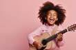 Joyful child playing guitar isolated on pink background with copy space. Creative banner for children music school.