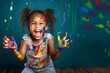 portrait of a funny african child girl shows hands dirty with paint