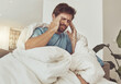 © Clement Coetzee/peopleimages.com - Stress, headache and sick man on a sofa with burnout, vertigo or pain from insomnia at home. Anxiety, migraine and male person in a lounge with temple massage for dizziness, congestion or head cold