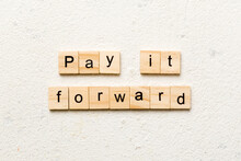 Pay It Forward Word Written On Wood Block. Pay It Forward Text On Cement Table For Your Desing, Concept