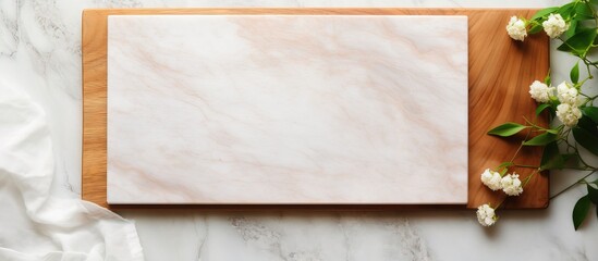 Canvas Print - Top view of wooden cutting board on marble background with leaves and linen napkin