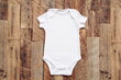 Baby onesie mock up . Blank bodysuit wooden wall	