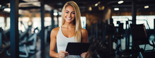 Positive pretty girl with an athletic figure holding tablet computer. Healthy lifestyle and fitness concept. Copy space	