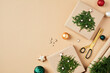 © photoguns - Flat lay Christmas composition with DIY Christmas gifts with fir branches, decorations, balls, scissors, wrapping paper on beige background.