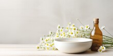 Bowl With Chamomile Flowers And Bottle Of Essential Oil On Light Background : Generative AI