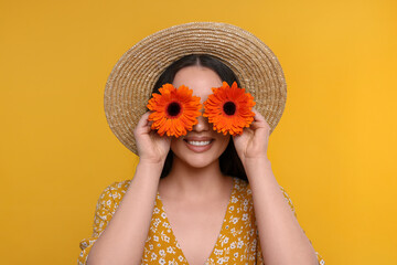 Canvas Print - Woman covering her eyes with spring flowers on yellow background