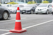 Red traffic cones at parking area in daytime.