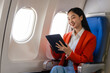 Young asian chinese japanese people female adventurer in-flight, mapping out destinations as she voyages worldwide. woman passenger of airplane. travel around the world.
