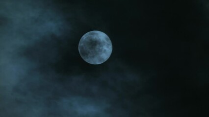Wall Mural - a full bright moon on a dark cloudy night. creepy clouds in the background of the moon like in thril