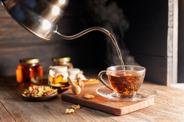 Make a cup of hot tea or a glass of chrysanthemum tea. and chrysanthemums lay on the wooden table Pouring healthy drinks, herbal drinks and medical concept