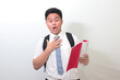 © Yazid Nasuha - Indonesian senior high school student wearing white shirt uniform with gray tie shocked and looking at his note book. Isolated image on white background